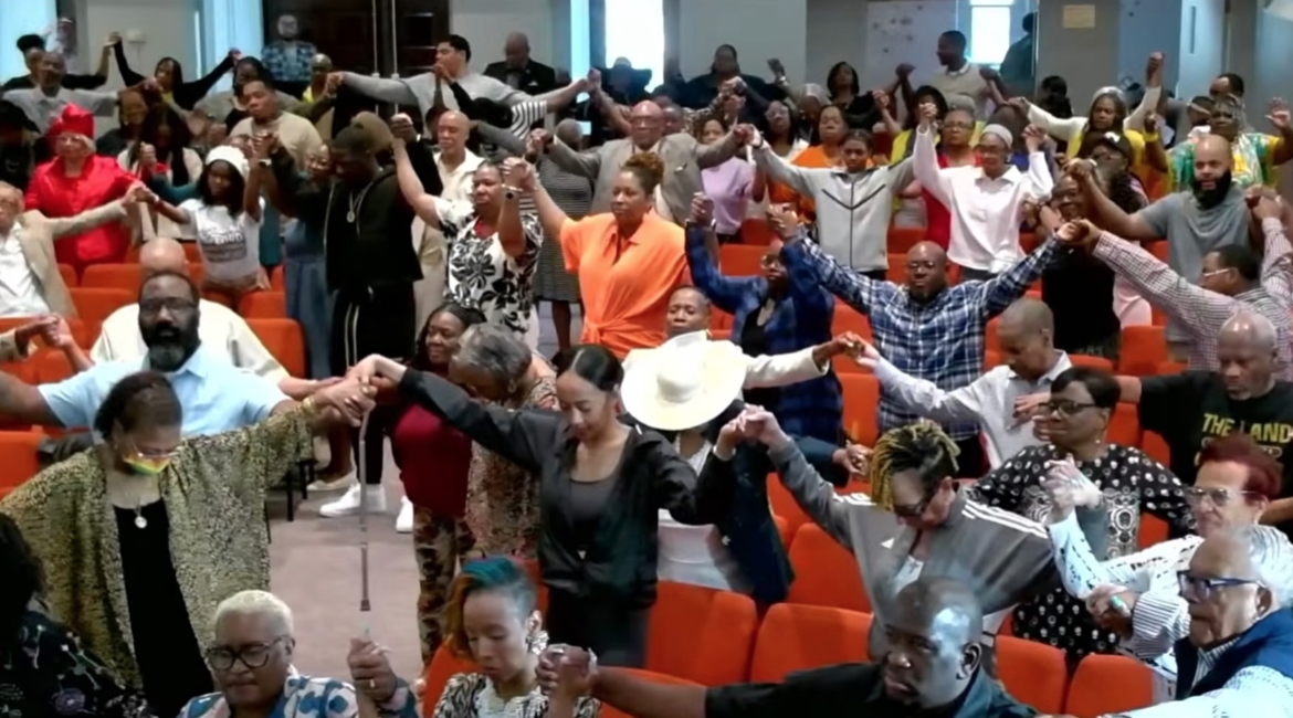 Congregation holding hands in prayer across the sanctuary